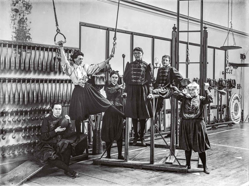 Passionnée de tennis, de vélo ou encore d’automobile, Alice Austen documente l’essor du sport chez les femmes de la grande bourgeoisie à la fin du XIXe siècle. L’existence du Berkeley Ladies’ Athletic Club, un club féminin de gymnastique situé dans Manhattan, est révélatrice du phénomène. En 1893, elle y photographie ses amies : Daisy Elliott (tenant les anneaux), qui dirige le lieu, et avec qui elle a une courte liaison, ou Violet Ward (à l’extrême gauche, tenant un ballon), autre compagne amoureuse de Daisy Elliott.Crédit photo : Collection of Historic Richmond Town