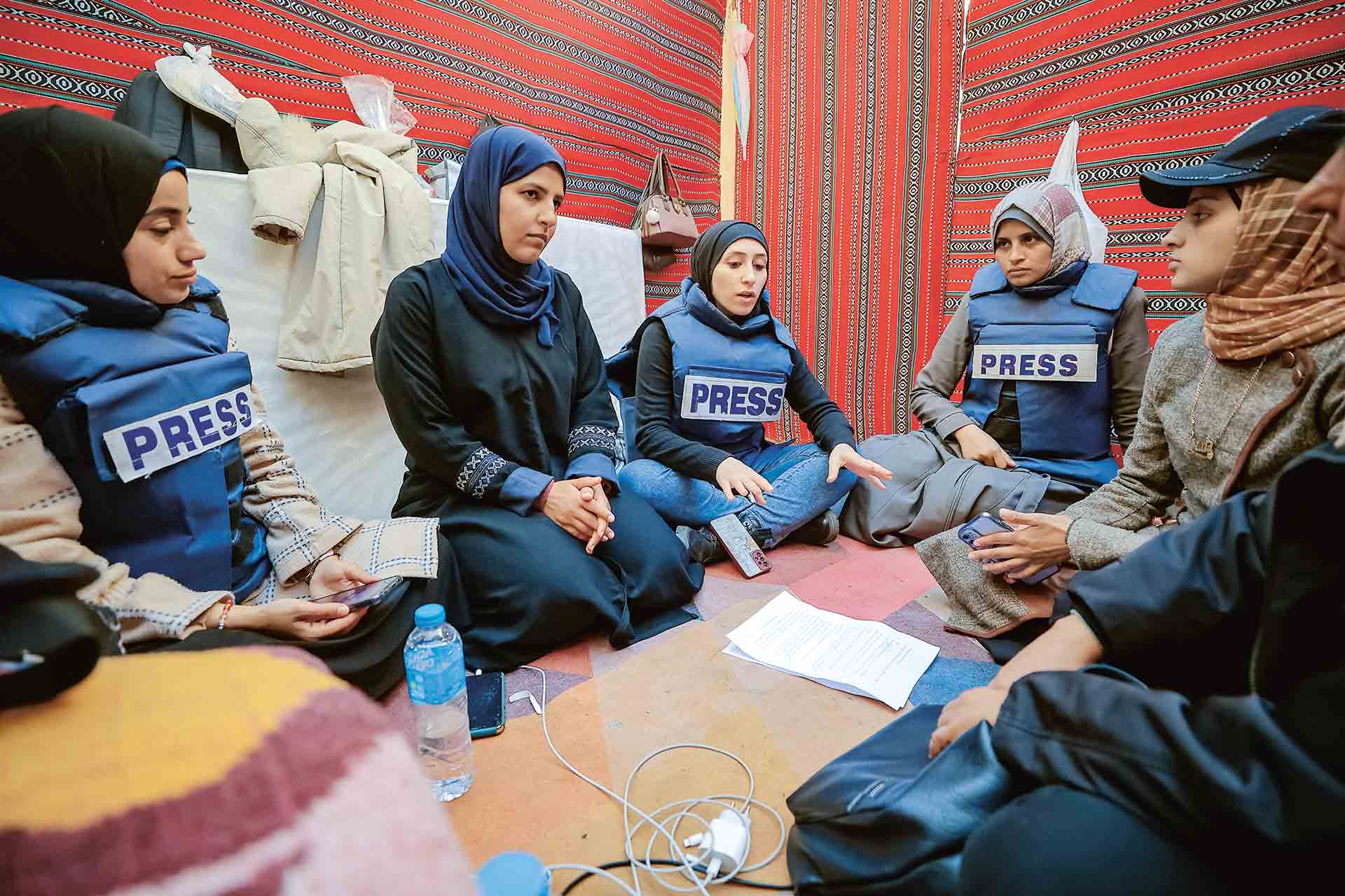 À l’hôpital Nasser, des journalistes échangent dans la tente mise en place par l’association Filastiniyat. De gauche à droite : Du’aa Abu Ta’ima (journaliste indépendante), Aya Abu Judeh (reportrice pour un média allemand), Du’aa Khaled (qui travaille pour la chaîne palestinienne Al-Quds Today) et Hala Asfour.