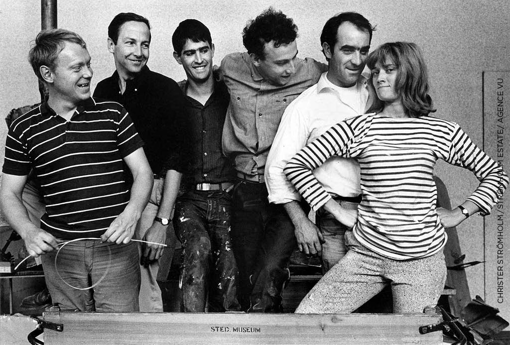 Niki de Saint Phalle (à droite) à Amsterdam en 1962 avec, de gauche à droite, les sculpteurs Per Olof Ultvedt, Robert Rauschenberg, Martial Raysse, Daniel Spoerri et Jean Tinguely, pendant le montage de leur exposition Dylaby (Labyrinthe dynamique). Christer Strömholm / Strömholm Estate / Agence VU