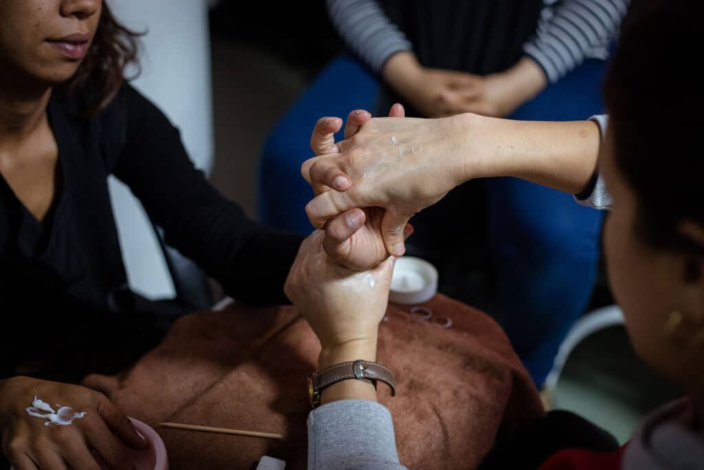 En formation d’esthéticiennes, des mères célibataires s’entraînent à se masser les mains entre elles. Milla Morisson / HansLucas pour La Déferlante