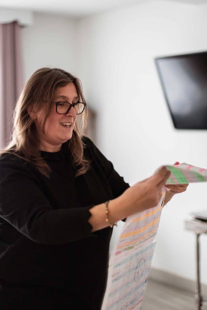 Daisy Audouze en train de lire son planning de
la semaine. L’accueil de plusieurs enfants (jusqu’à quatre) oblige souvent les assistantes maternelles
à dépasser les 45 heures hebdomadaires. Crédit : Elsa Biyick pour La Déferlante.