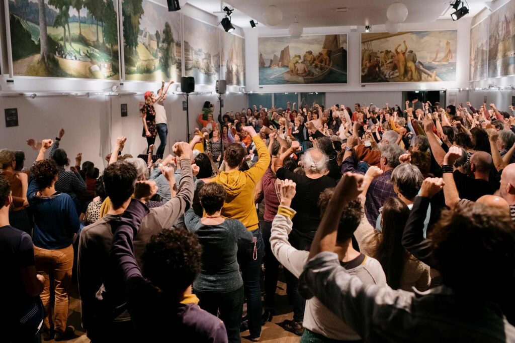 Entre novembre 2024 et janvier 2025, plusieurs initiatives ont commémoré le centenaire de la grève des sardinières de Douarnenez. Ici, 300 personnes sont réunies à la salle des fêtes de la ville pour répéter les chants qui rendent hommage aux 2 000 ouvrières qui se sont mobilisées avec succès pour de meilleurs salaires.